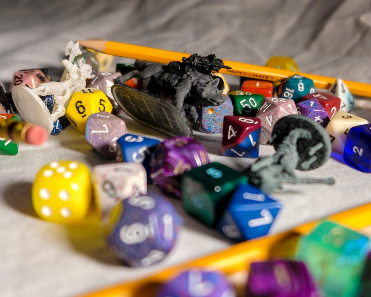 creative-02 High angle of color dices in different shapes scattered on table with small toy animals and pencils during game